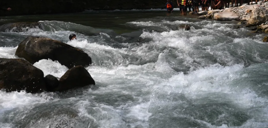 Swimmer navigating whitewater rapids